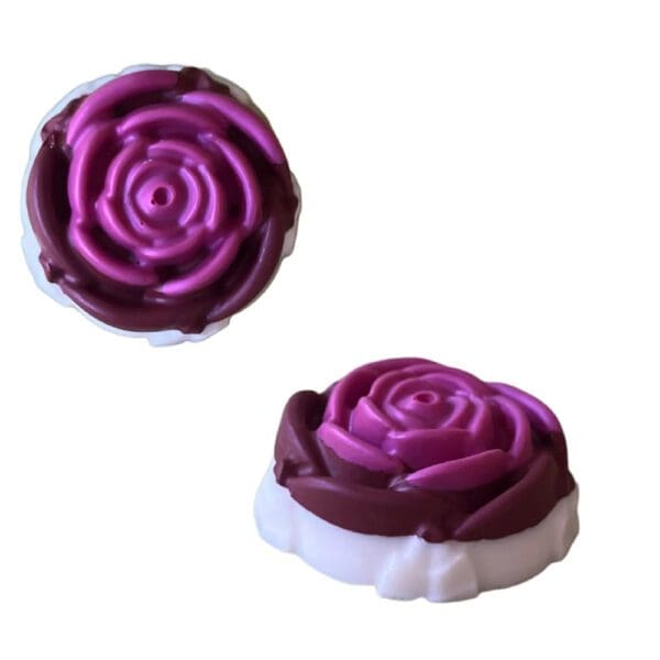 Two purple and white rose shaped soaps.