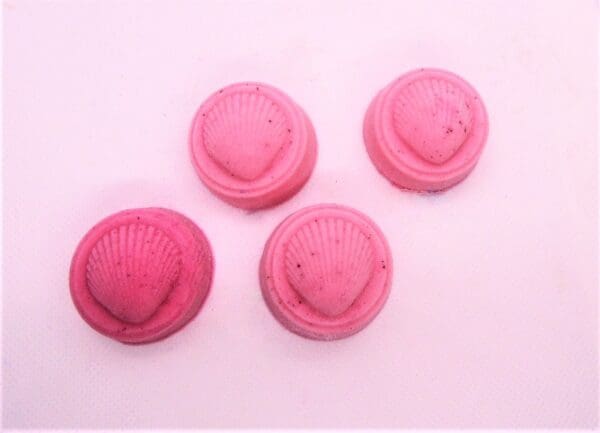 Four pink seashell-shaped soaps.