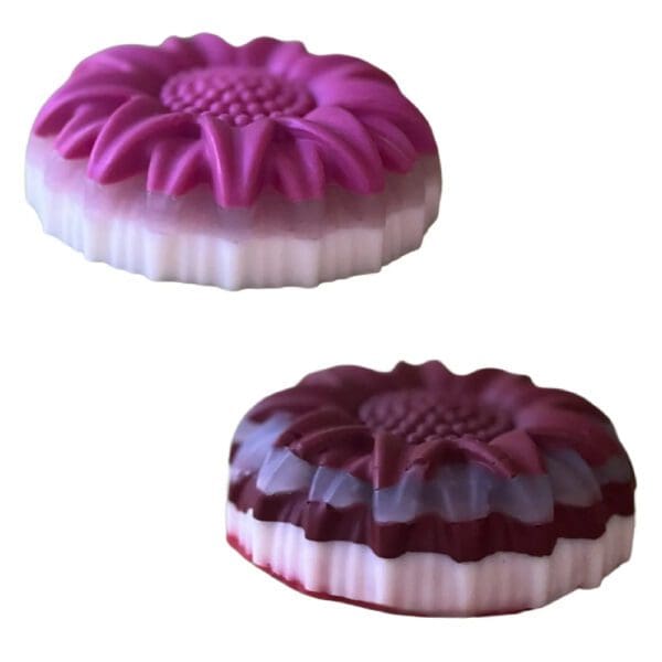 Two floral-shaped pink and purple soaps.