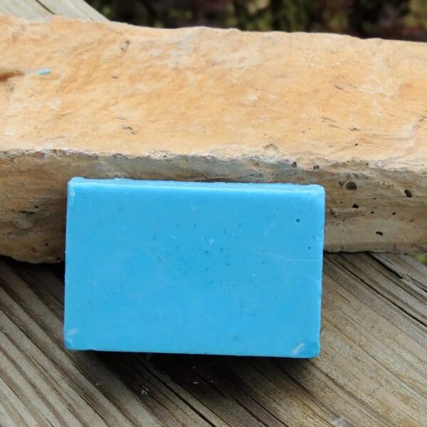 Blue soap bar on wooden surface.