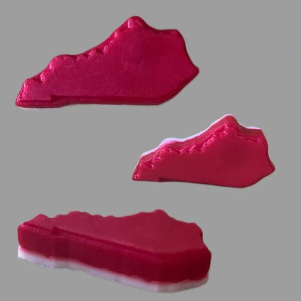 Three red 3D printed Kentucky shapes.