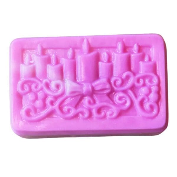 Pink soap with candles and bow design.